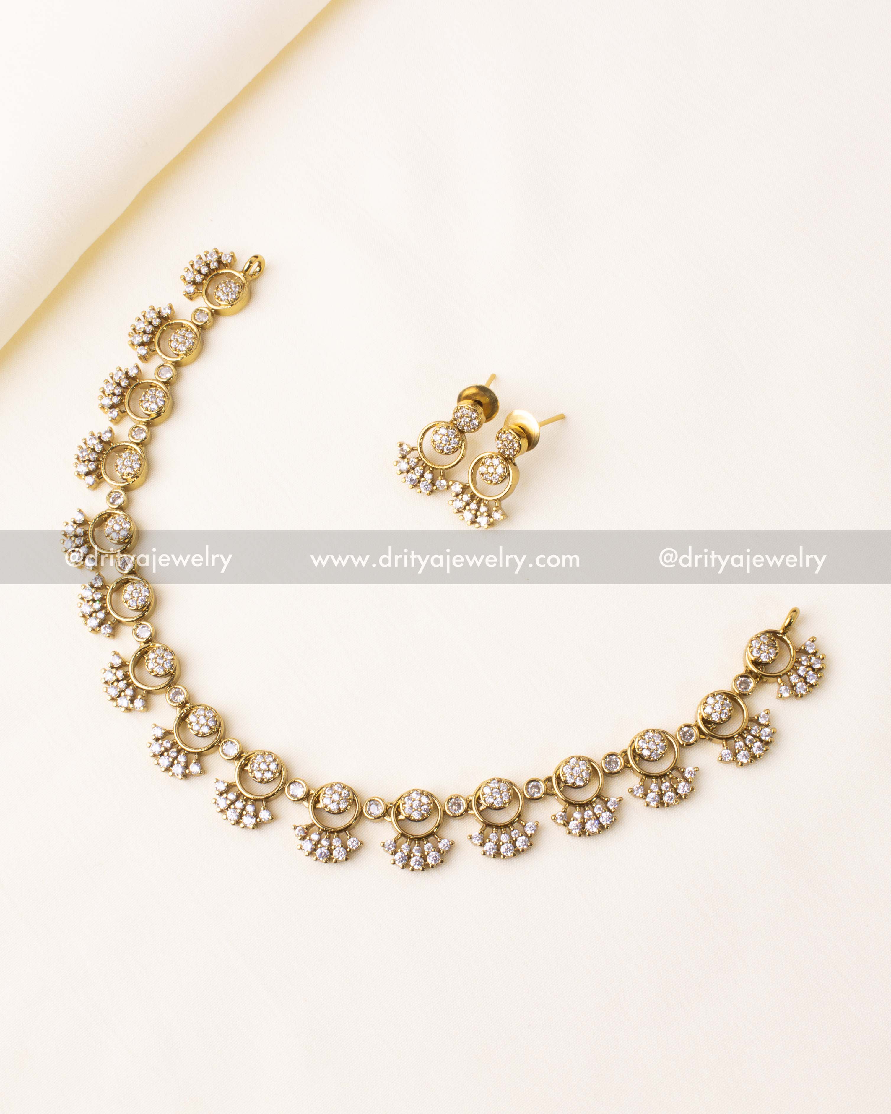 Premium gold-plated short necklace set featuring cubic zirconia stones and crescent motifs.