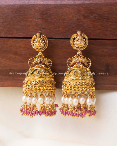 Exquisite temple Jhumka earrings with gold detailing, pearl drops, and pink crystal beads.
