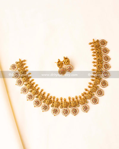 Heritage-inspired long necklace with intricate peacock carvings, gold finish, and pink-green stone embellishments.