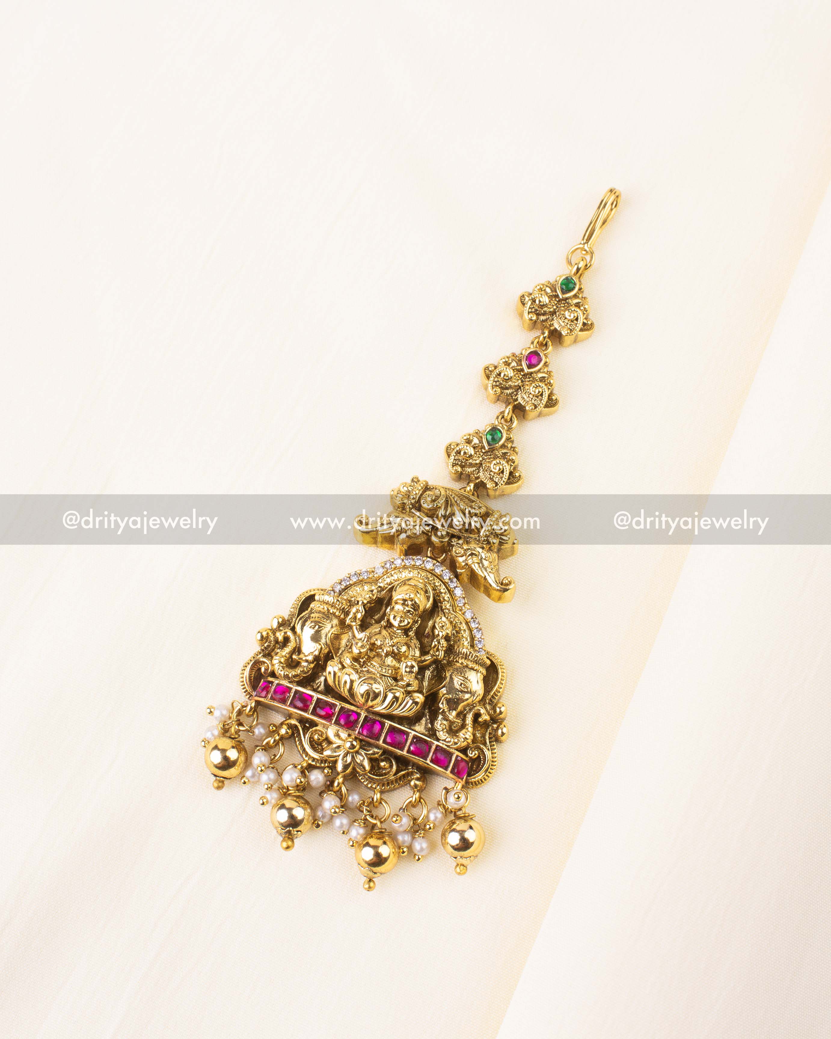 Antique gold maang tikka featuring Lakshmi Devi and classic bead detailing.