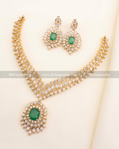 Short gold‑plated necklace with emerald‑green centerpiece and CZ halo, with matching earrings.