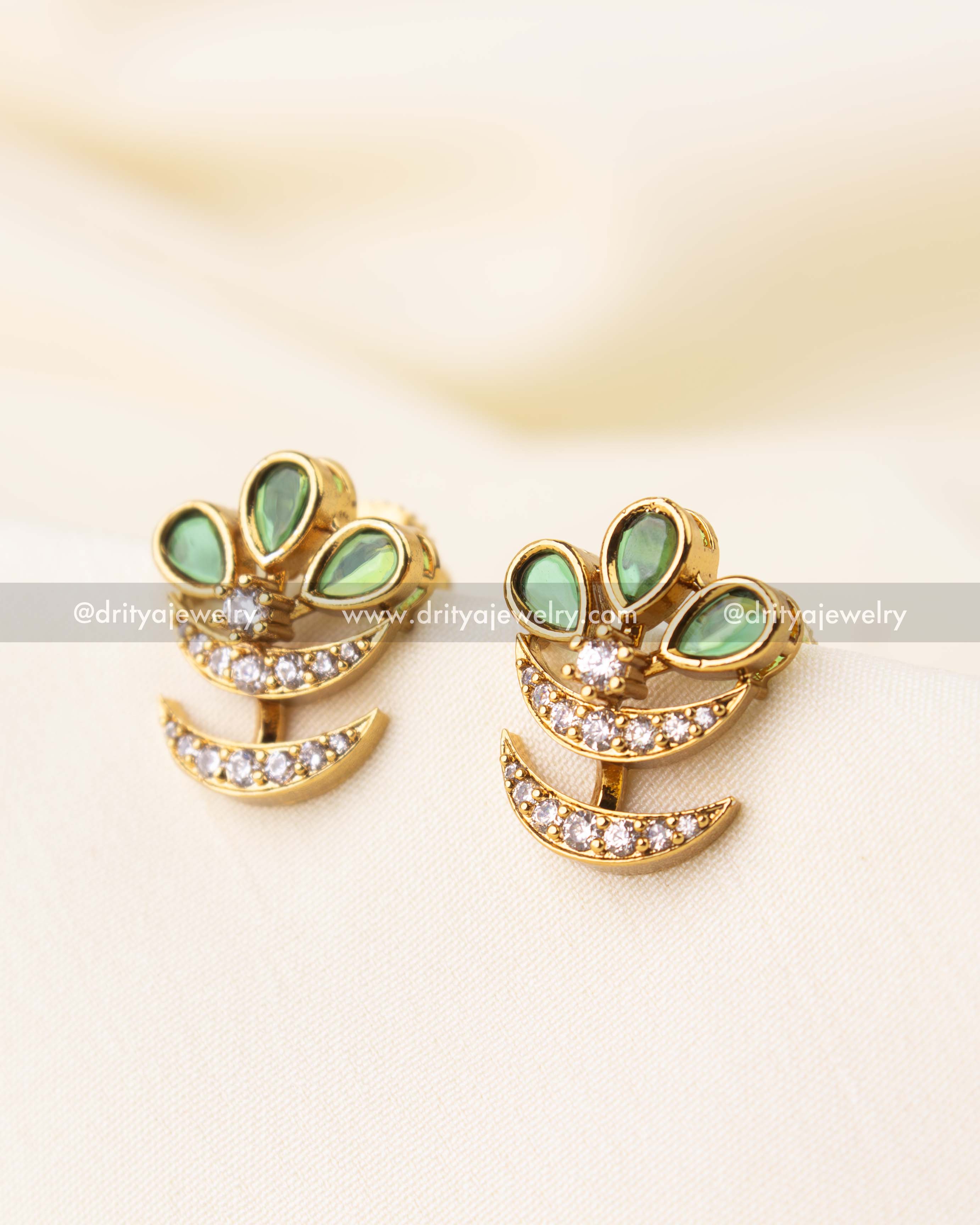 Elegant gold-toned stud earrings featuring green teardrop stones and crescent-shaped CZ detailing.