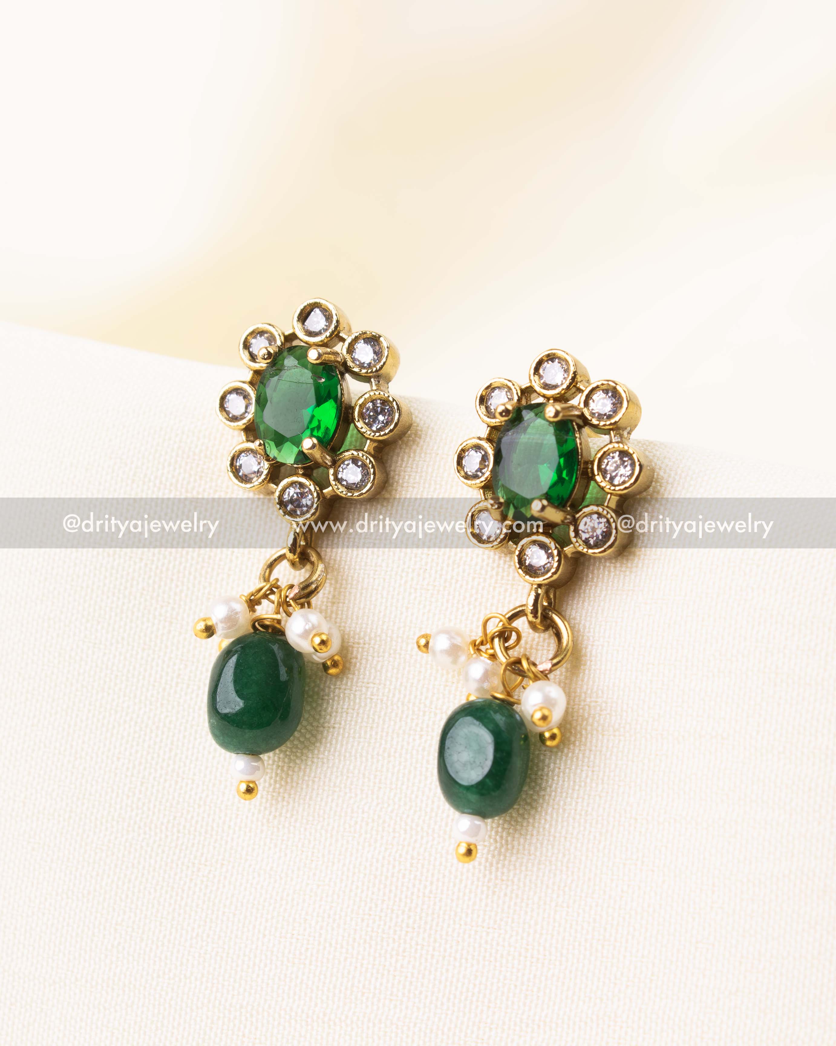 Matching emerald green earrings with floral AD design and green beads.