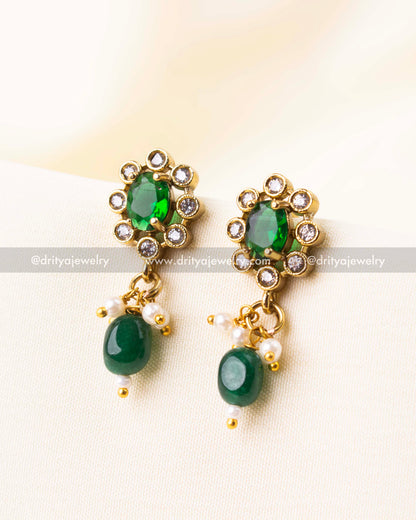 Matching emerald green earrings with floral AD design and green beads.