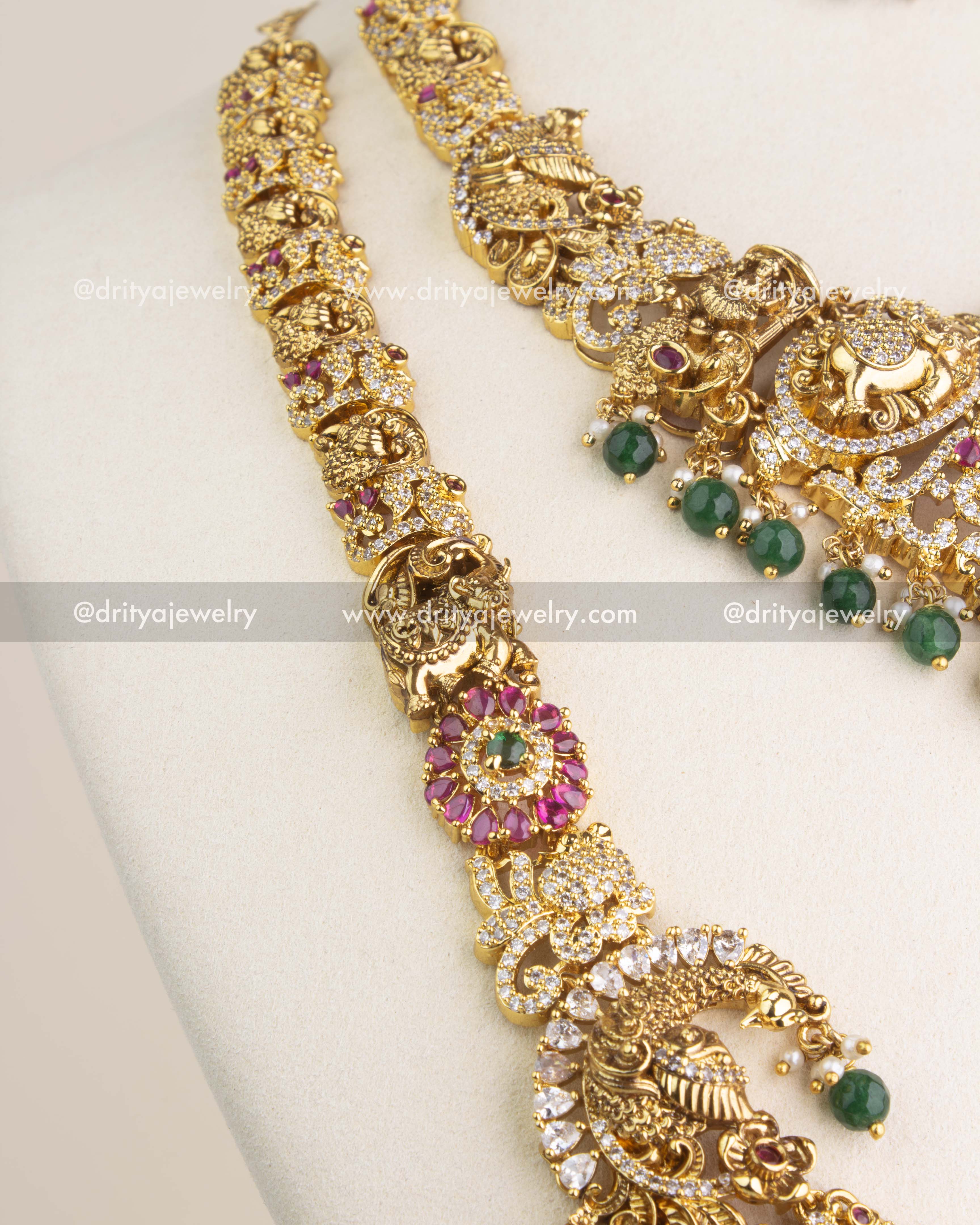 Close view of Nakshi temple jewelry chain with floral motifs, ruby stones, and CZ highlights.
