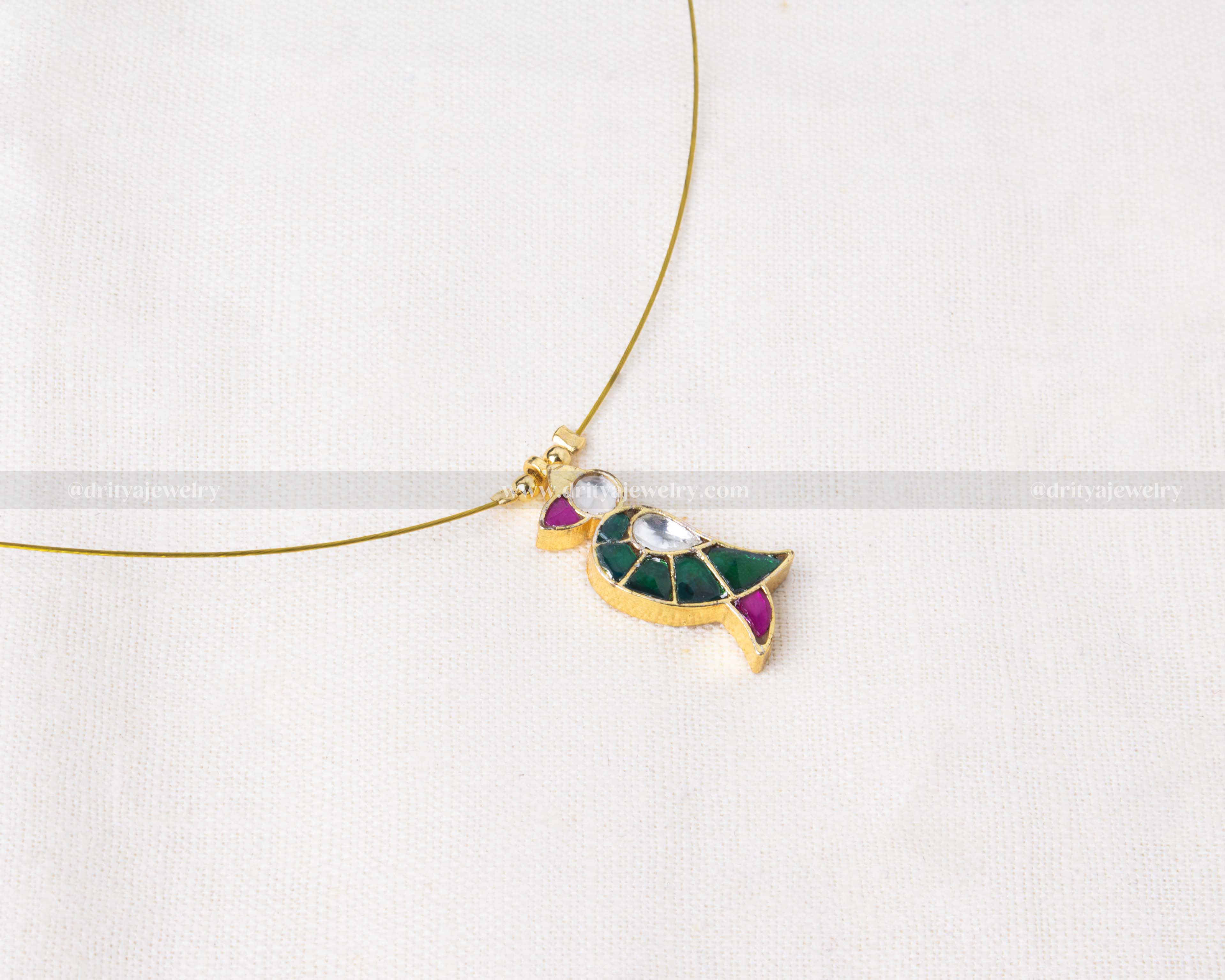 Minimalist invisible necklace featuring a bird-shaped pendant with green and pink Jadua stones.