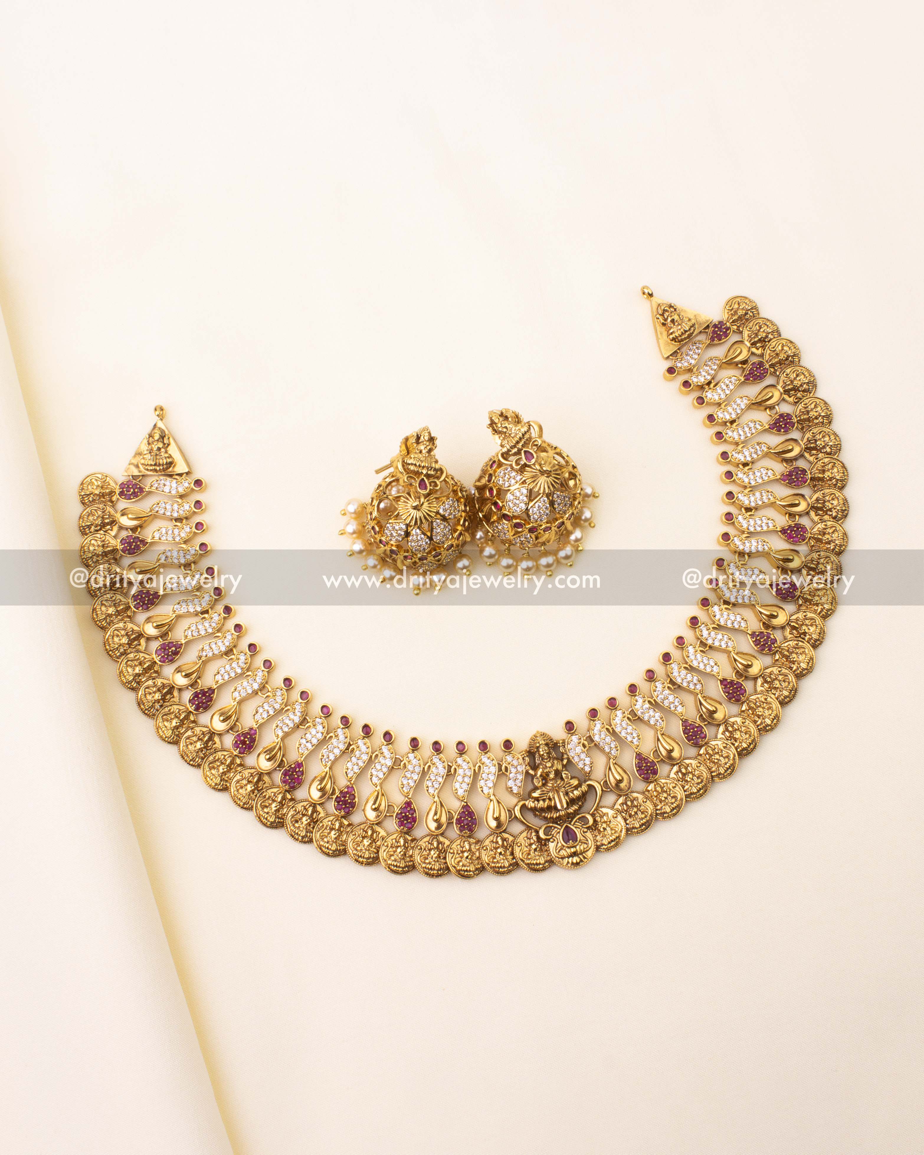 Traditional Kasulu short necklace with Lakshmi motifs, ruby accents, and matching temple jhumkas.