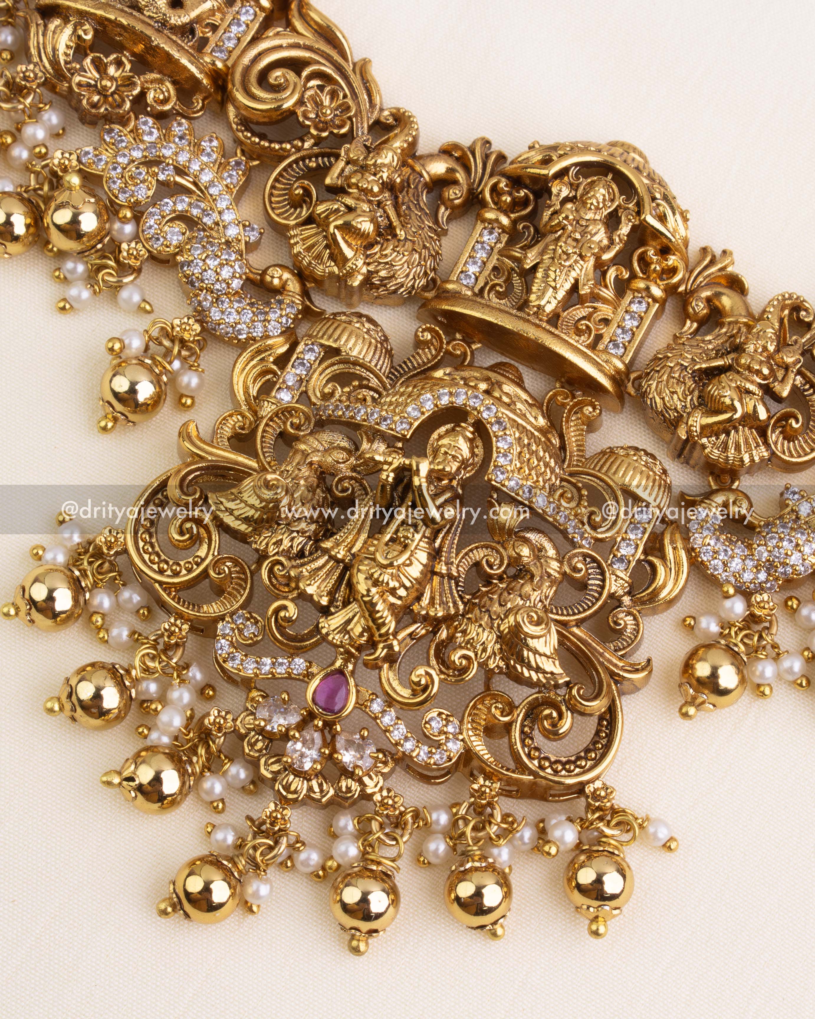 Krishna seated in temple arch flanked by peacocks, embellished with white CZ stones and ruby accent