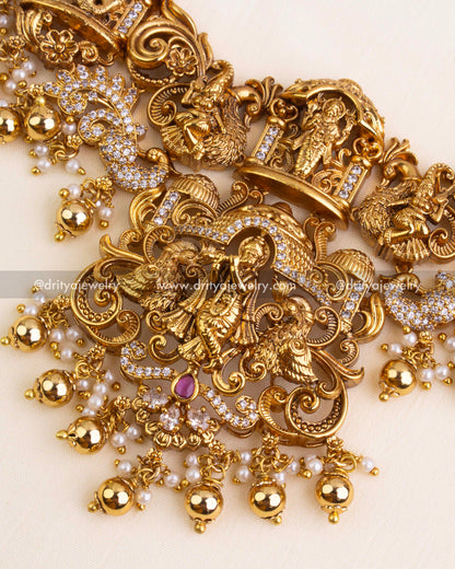Krishna seated in temple arch flanked by peacocks, embellished with white CZ stones and ruby accent