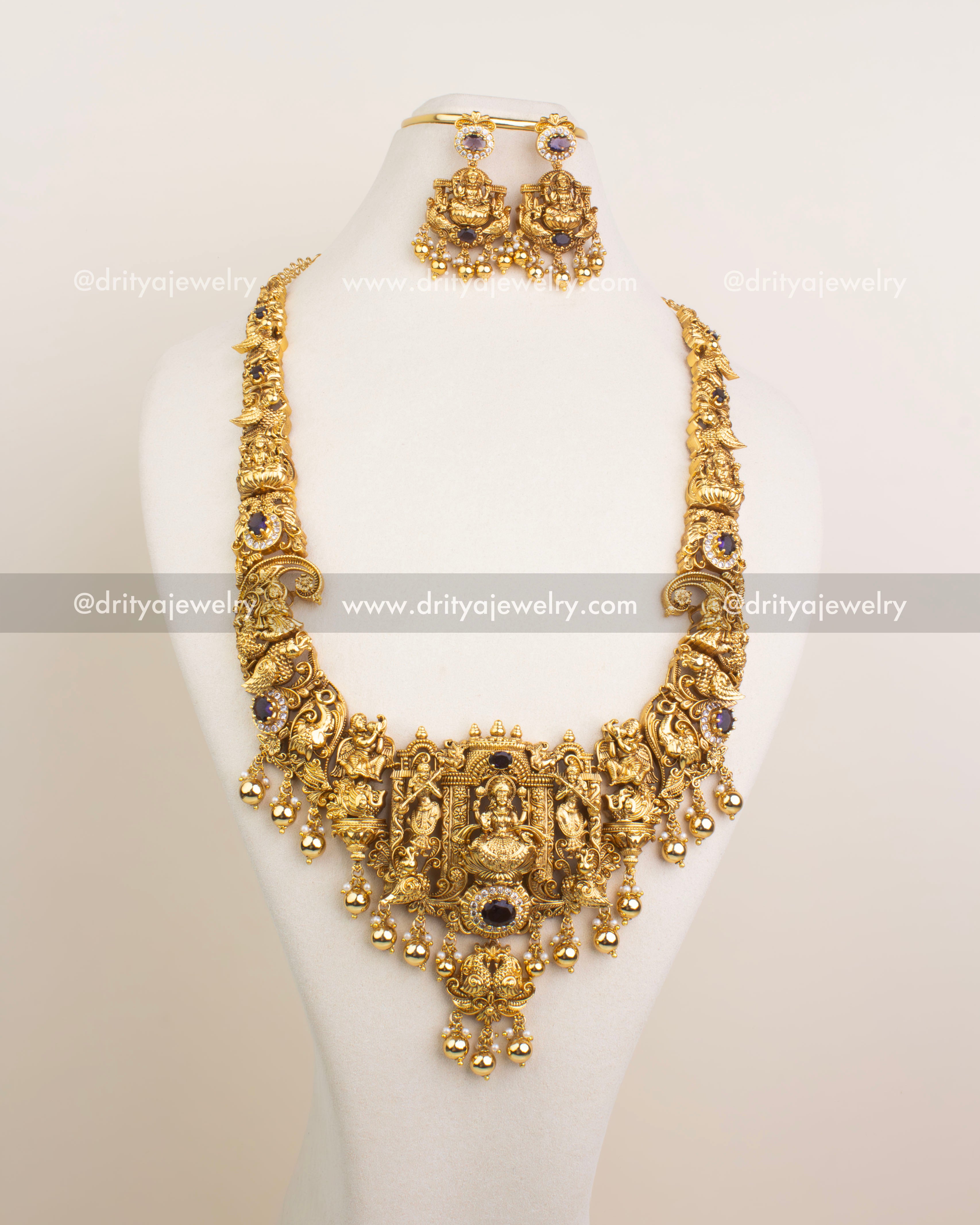 Side-angle view of Nakshi bridal long necklace set featuring Lakshmi Devi motif, purple stones, white CZ detailing, and traditional craftsmanship