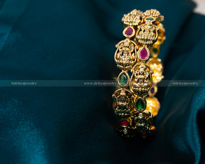 Exquisite Lakshmi Devi Temple Bangles from Dritya Jewelry, adorned with faux rubies and emeralds, capturing traditional Indian elegance and spirituality.