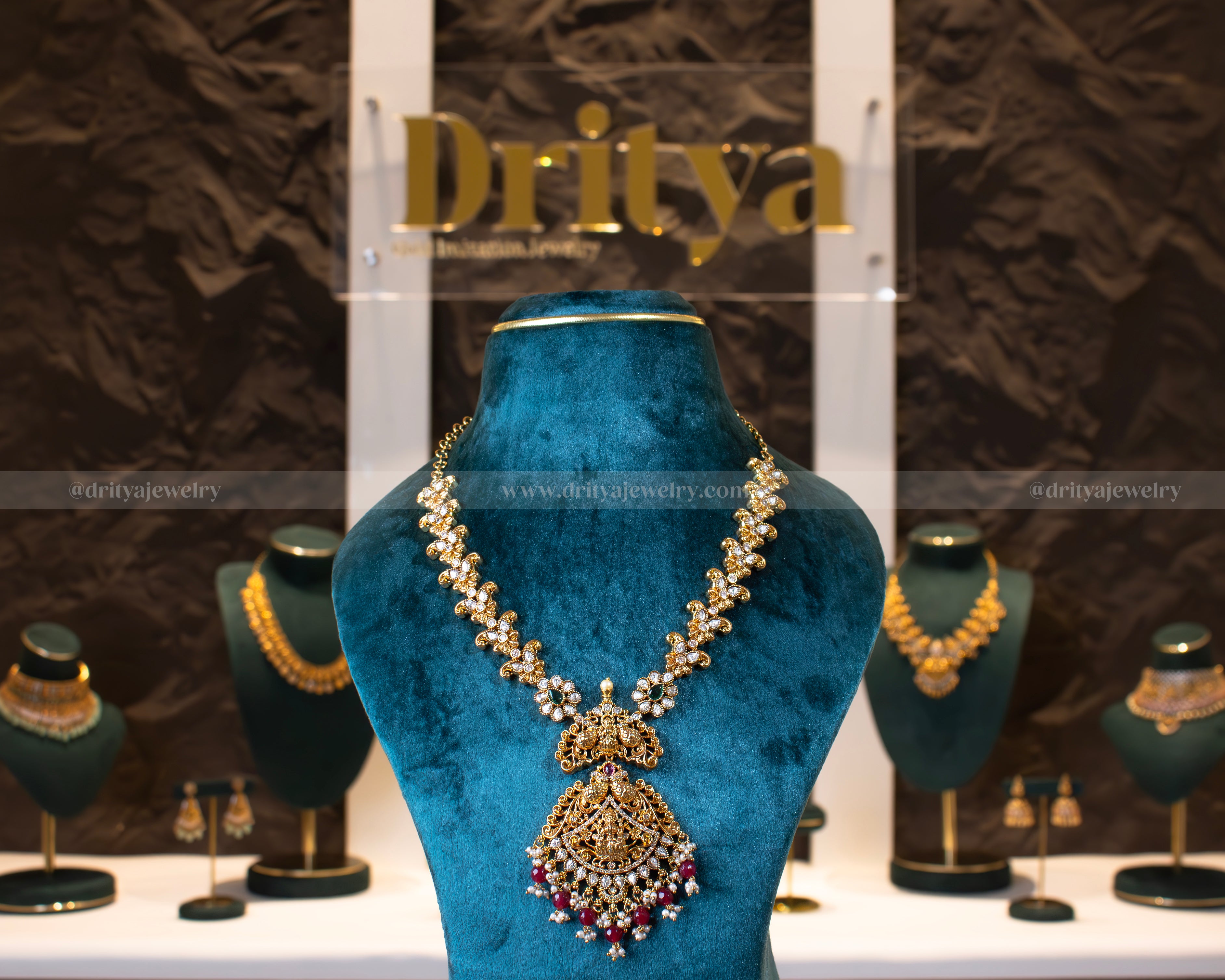 Front view of Dritya Jewelry's Lakshmi Devi Temple Necklace Set showcasing intricate gold-plated designs with vibrant stones.