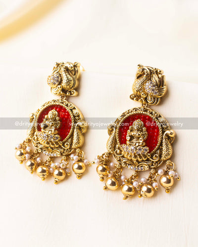 Traditional temple earrings with Lakshmi idol and hand-beaded red background.