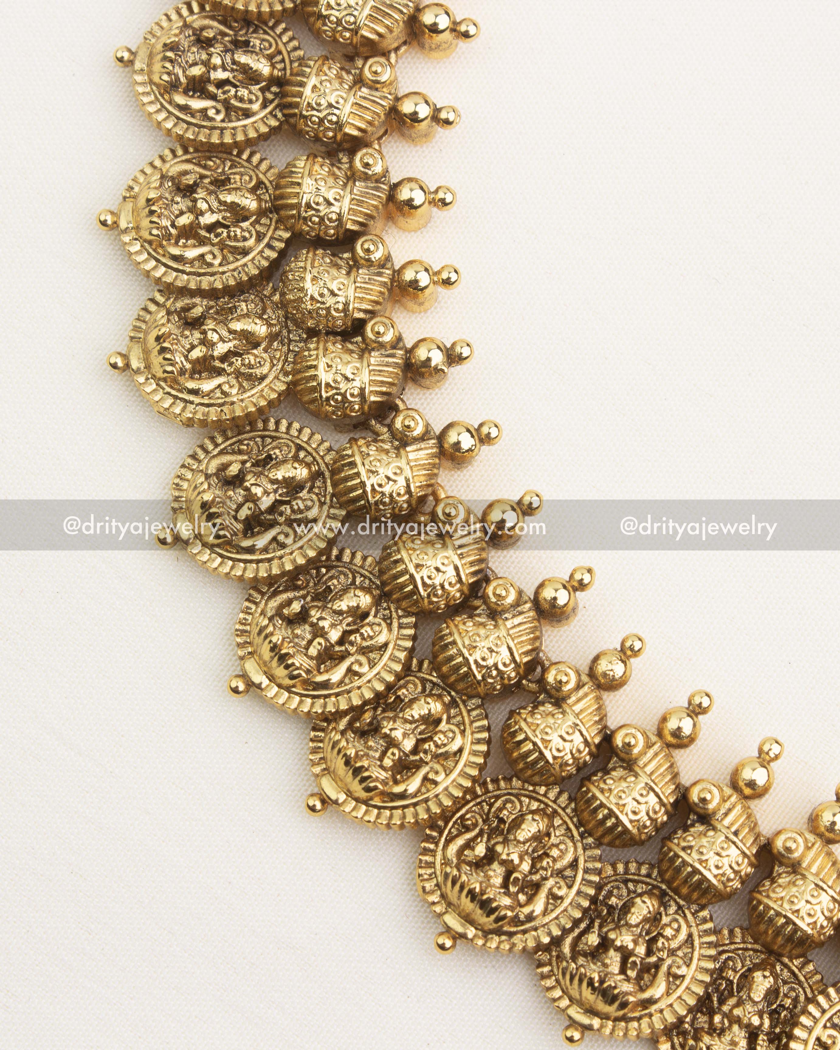 Close-up of antique gold Lakshmi coin motifs with textured dome elements and handcrafted temple detailing.