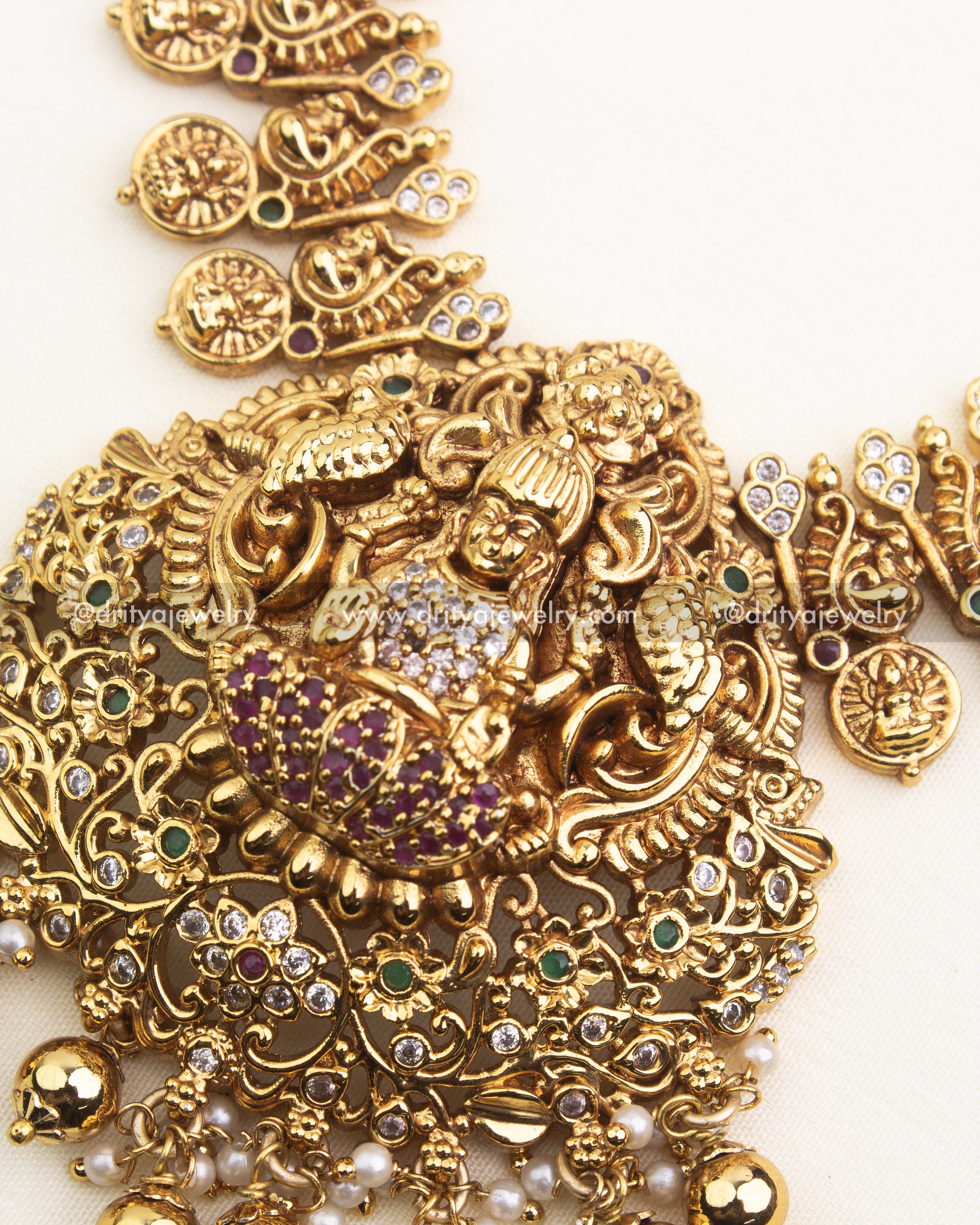 Intricate Lakshmi pendant with peacock motifs, ruby stones, and temple gold detailing.