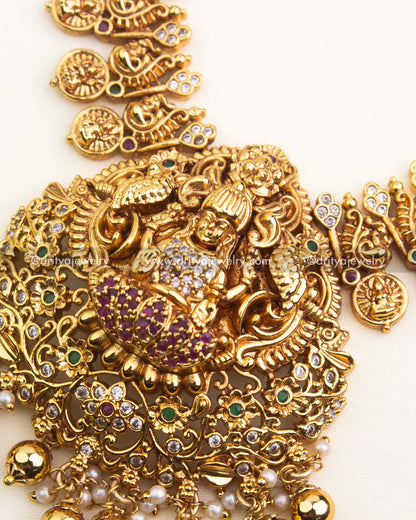 Intricate Lakshmi pendant with peacock motifs, ruby stones, and temple gold detailing.