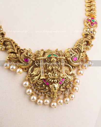 Detailed Lakshmi Devi pendant with Nakshi carvings, ruby and emerald Kemp stones, and pearl drops.