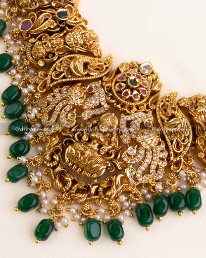 Detailed view of Lakshmi Devi pendant surrounded by elephants, CZ stones, and emerald green bead hangings.