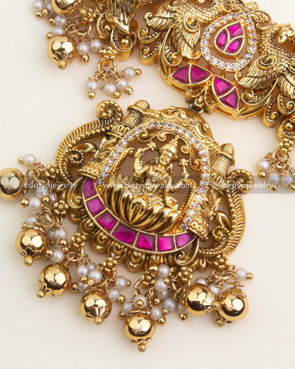 Temple Lakshmi pendant featuring ruby kemp stones, pearl clusters, and gold ghungroo drops.