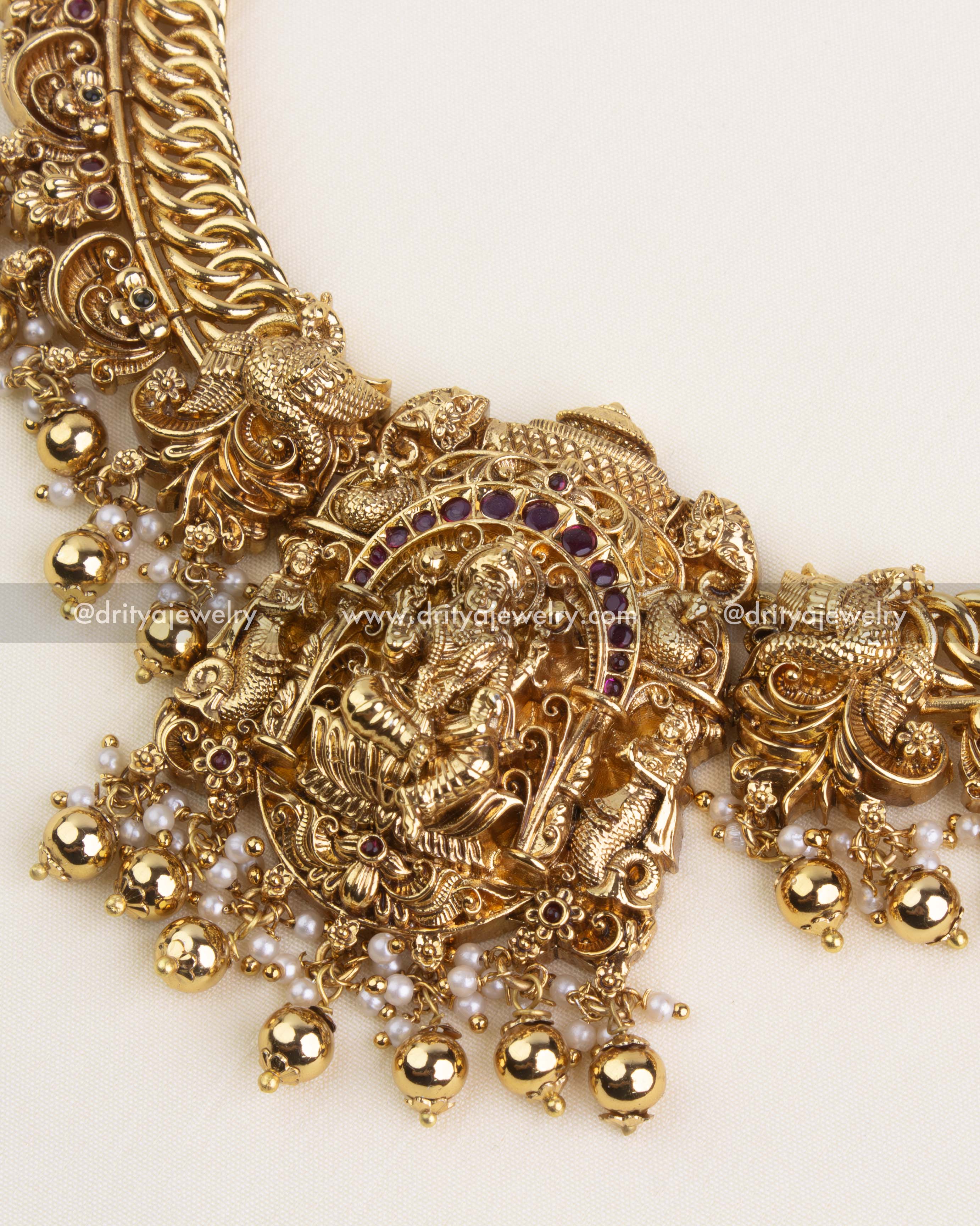 Detailed center pendant with goddess Lakshmi motif and hanging pearl-gold ball clusters.