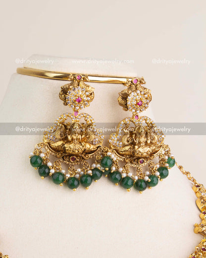 Nakshi temple dangler earrings with Lakshmi design, ruby kemp detailing, and green bead hangings.