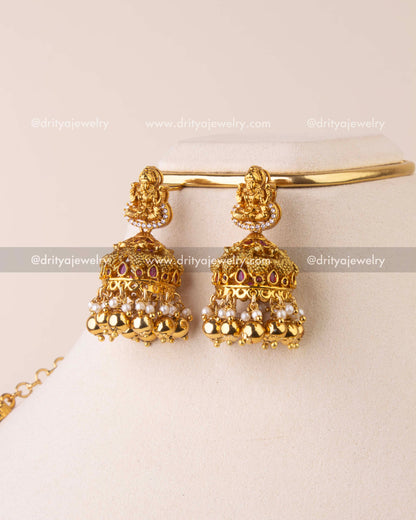 Traditional antique gold jhumka earrings with Lakshmi motif, Kemp accents, pearls, and golden bead drops.