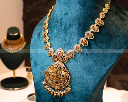 Display view of Dritya Jewelry's Lakshmi Temple Necklace Set, featuring detailed gold work, stones, and pearls.