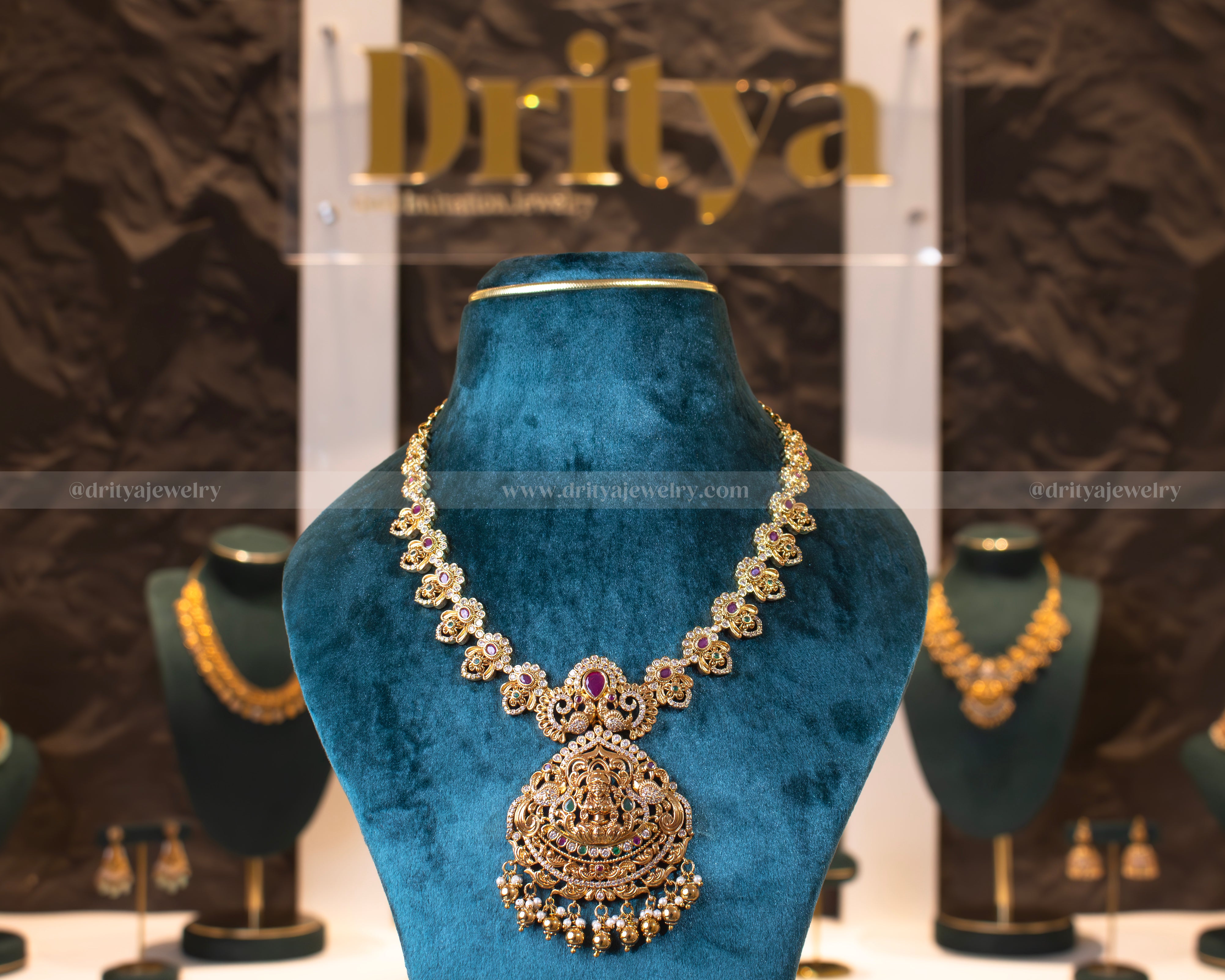 Front view of Dritya Jewelry's Lakshmi Temple Necklace Set showcasing intricate gold-plated design and temple-inspired motifs with vibrant stones.