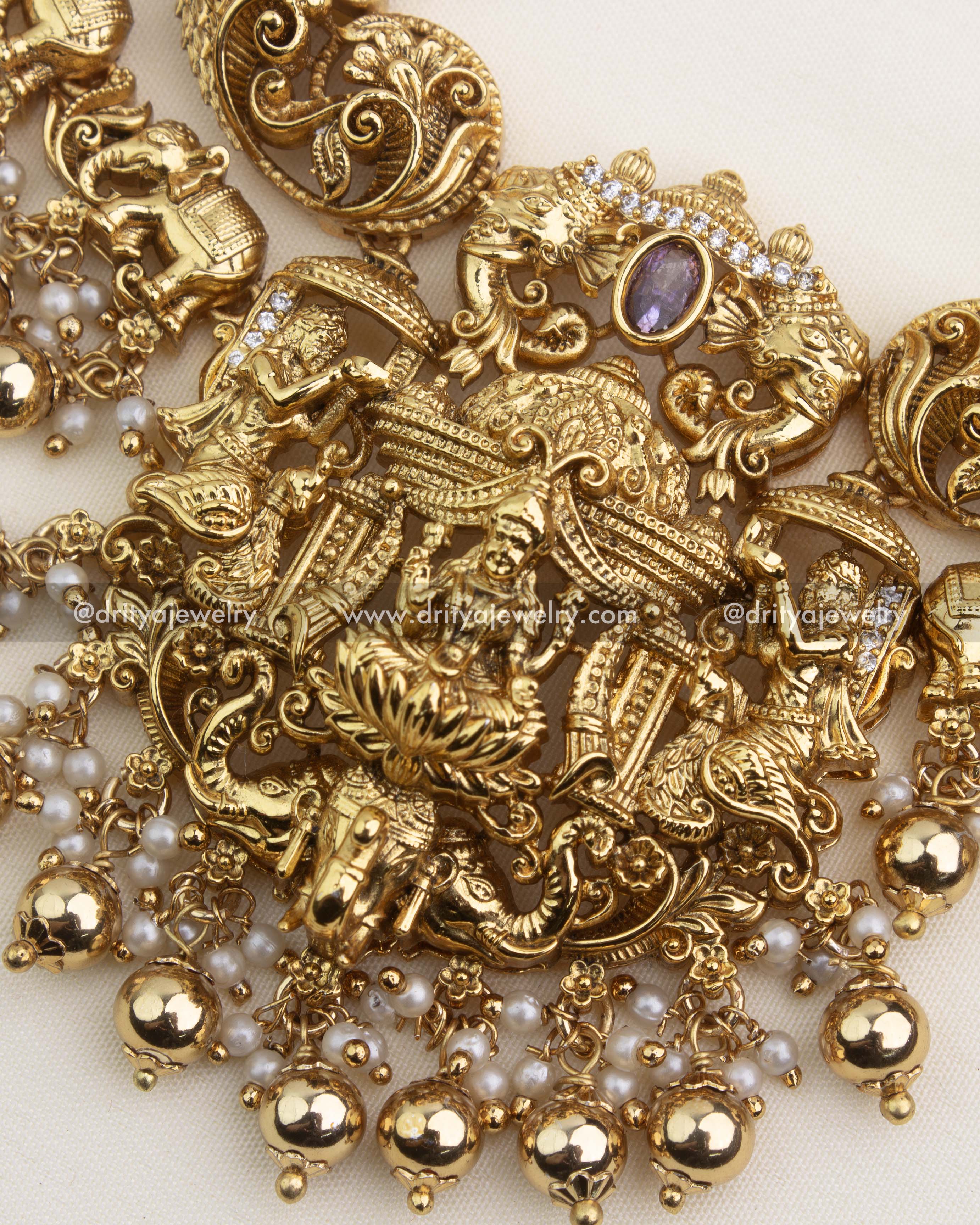 Detailed close-up of goddess Lakshmi pendant with peacocks, elephants, and pearl ghungroo hangings.