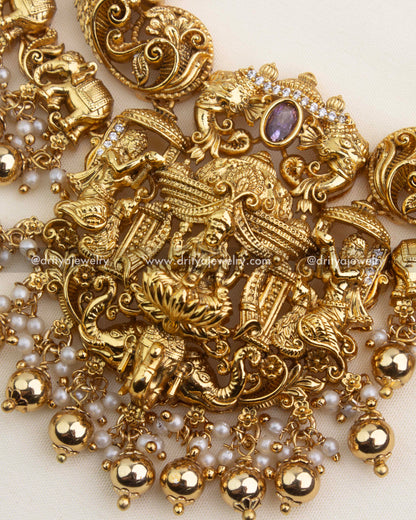 Detailed close-up of goddess Lakshmi pendant with peacocks, elephants, and pearl ghungroo hangings.