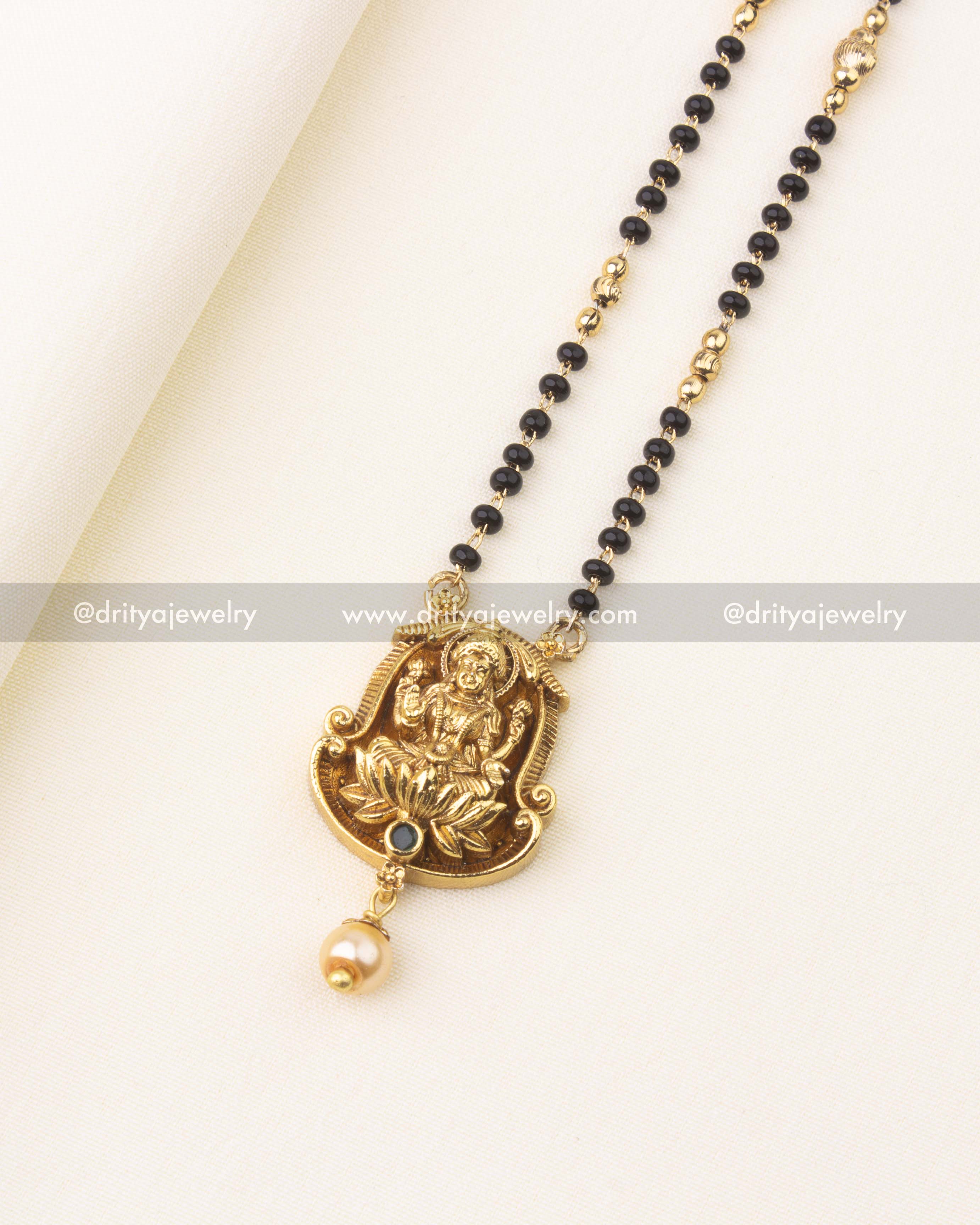 Detailed view of sleek black beads necklace chain with golden bead separators.