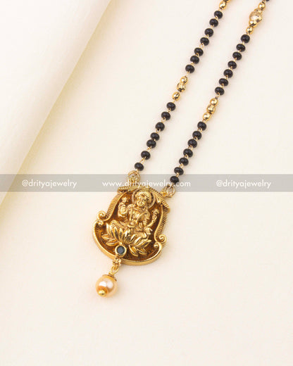 Detailed view of sleek black beads necklace chain with golden bead separators.
