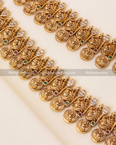 Intricate gold-plated Nakshi necklace with embossed coins, peacock carvings, and temple engravings.