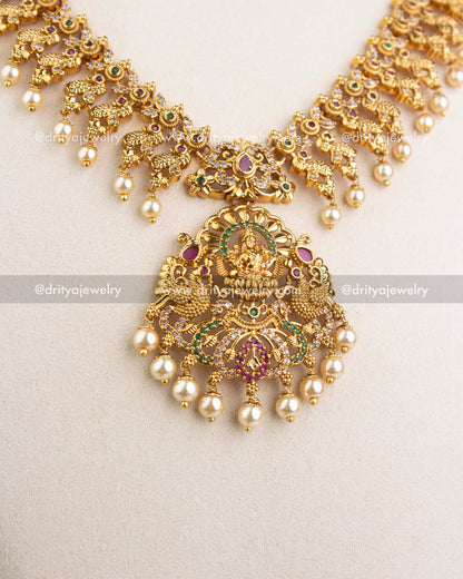 Large goddess Lakshmi pendant with pearl danglers in antique gold finish.