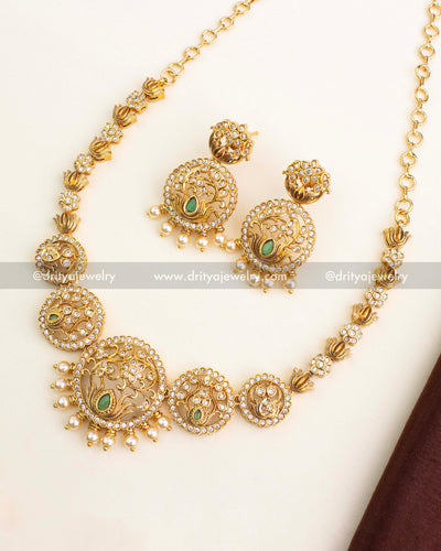 Gold-plated lotus motif short necklace set featuring circular CZ frames, green stone accents, and pearl droplets.