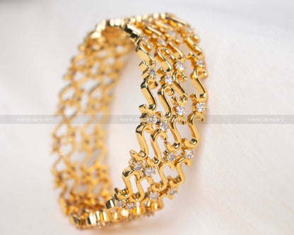 Elegant gold-tone bangle set with sparkling cubic zirconia, perfect for adding a touch of glamour to any outfit.