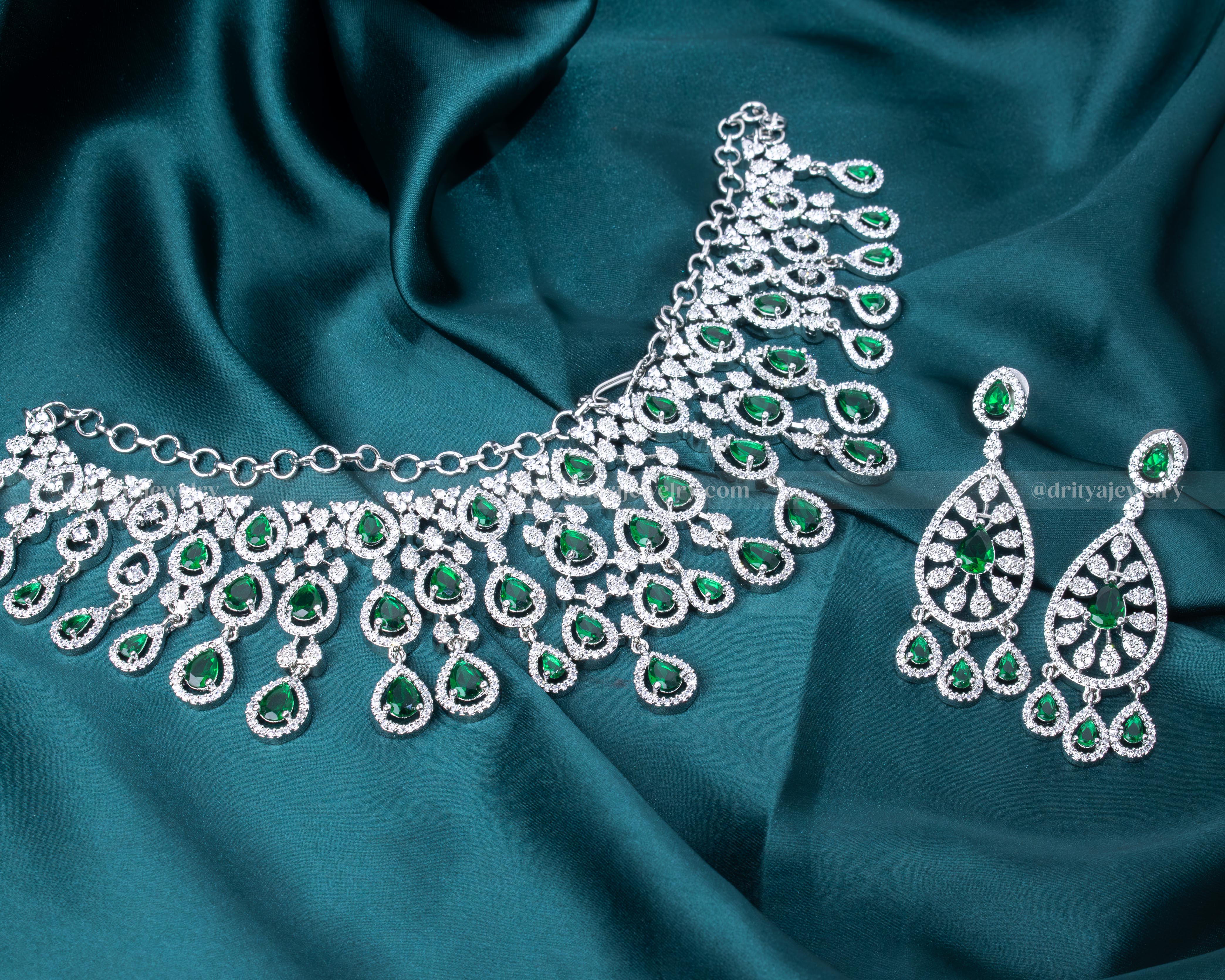 Elegant rhodium-plated necklace set with emerald and CZ stones, perfect for special occasions and formal events.