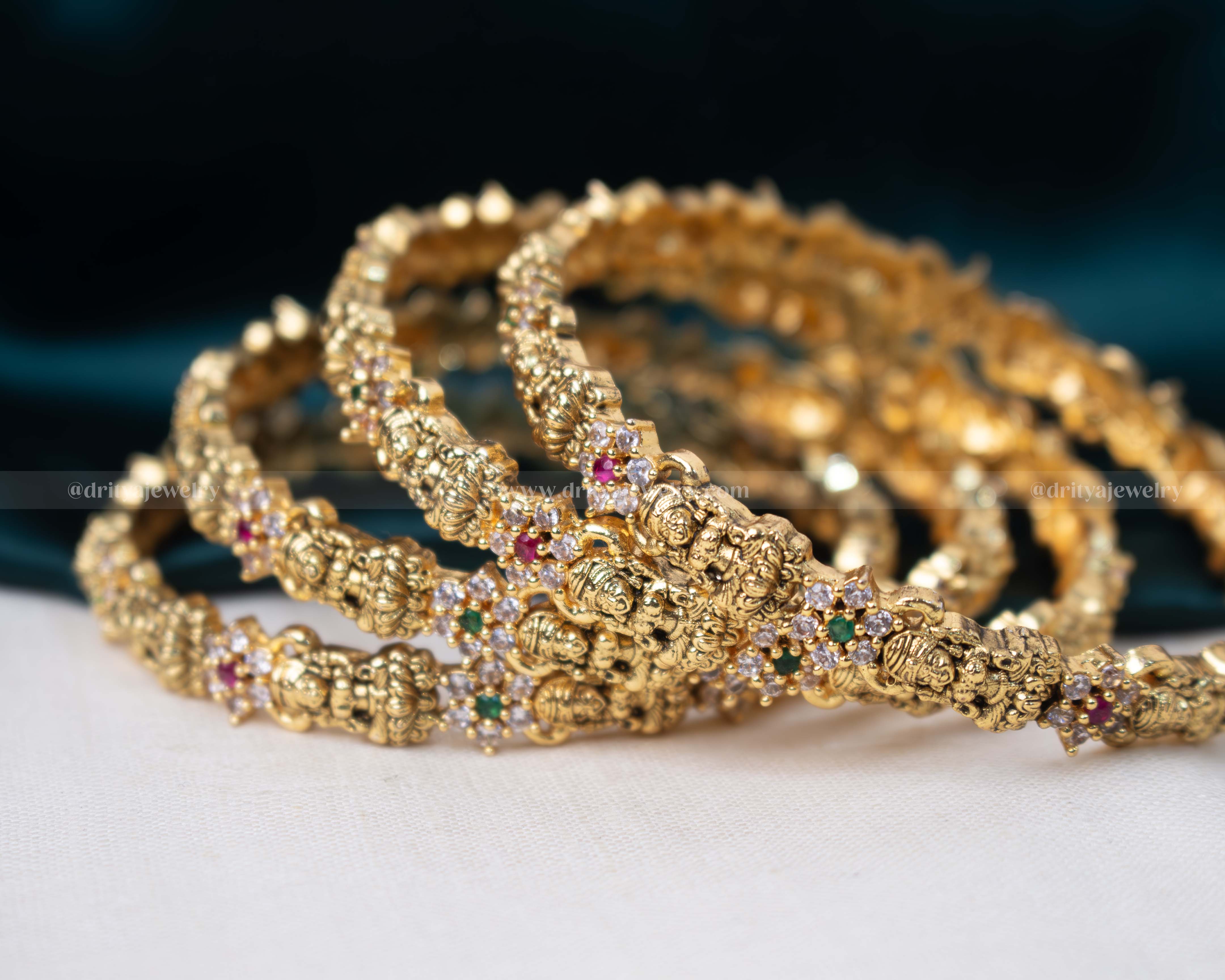 Elegant set of four golden temple bangles adorned with colorful faux gemstones and pearls, featuring intricate temple motifs.