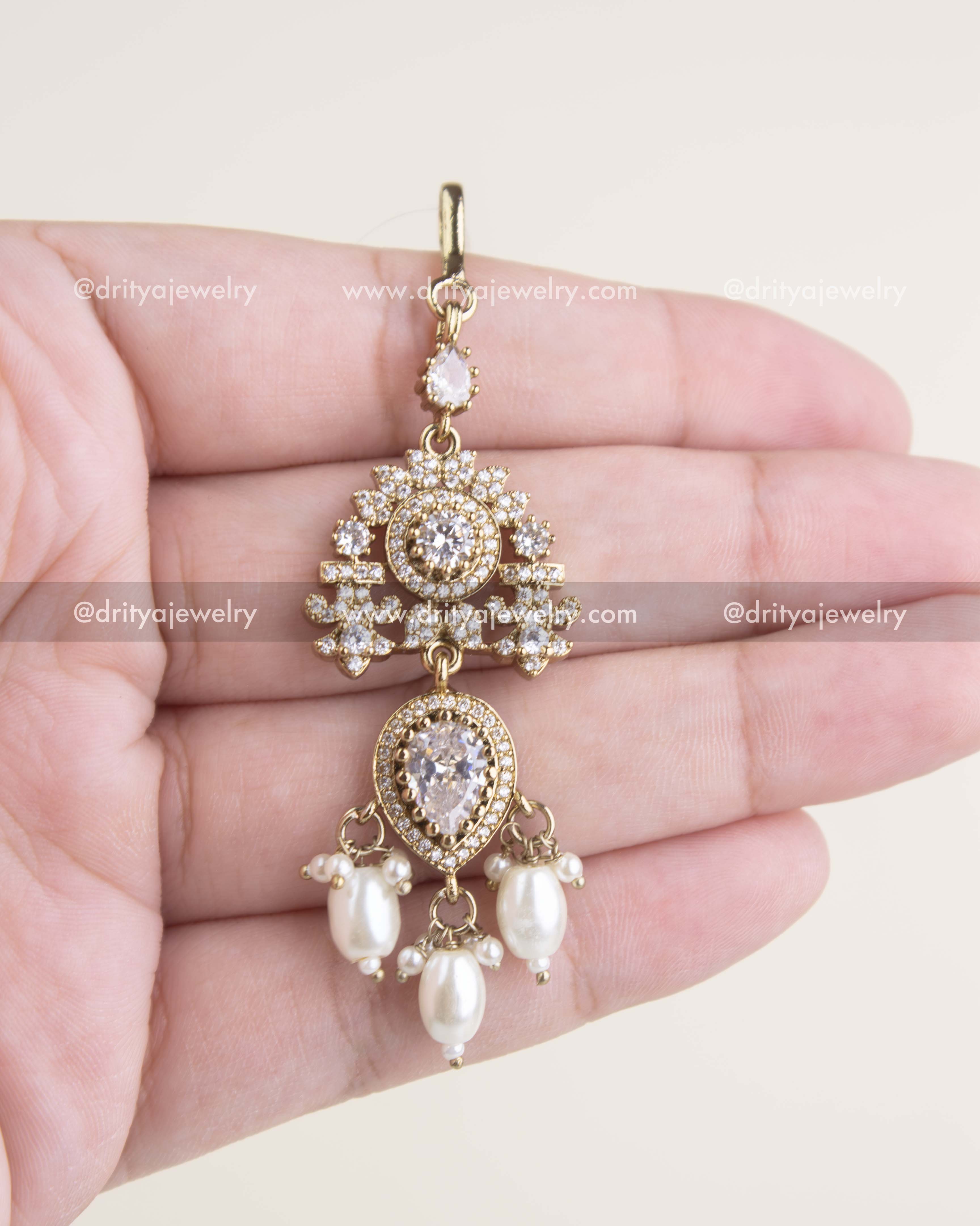 Russian emerald maang tikka with AD stones, floral motif, and Victorian gold polish.