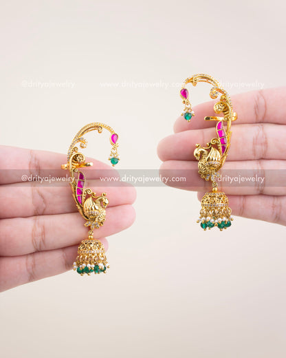 Handheld image of gold temple-style ear cuffs with peacock motif and green jhumka beads