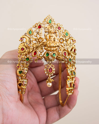 Antique gold temple vanki featuring Goddess Lakshmi, ruby and emerald stones, and peacock detailing.