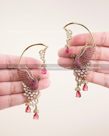 Victorian gold bird motif ear cuffs with pink stones and CZ detailing, displayed in hand.