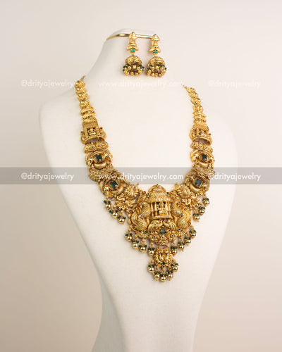 Traditional Nakshi temple long necklace with emerald green stones and antique gold finish - full view.