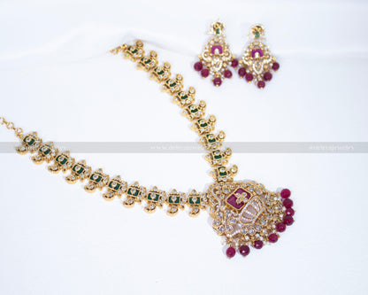 Front view of the Majestic Crown Style Necklace Set by Dritya Jewelry, featuring green and clear CZ stones with ruby accents.