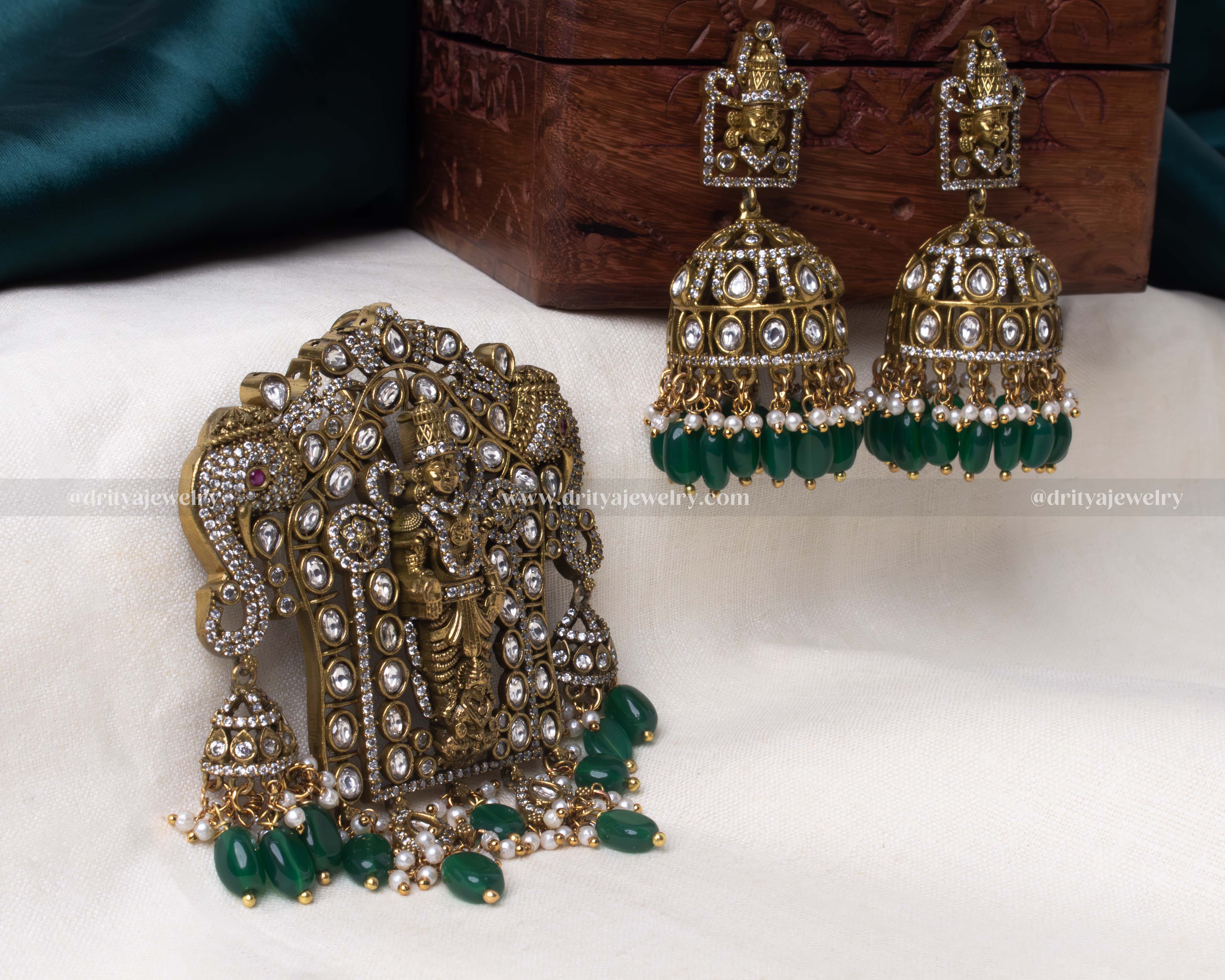 A complete view of the Venkateshwara Swamy pendant set featuring an intricately crafted oversized pendant with green beads and matching dome-shaped jhumkas.