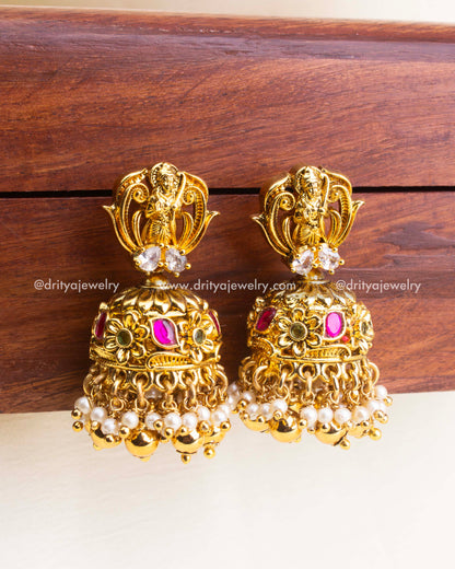 Traditional antique jhumka earrings with kemp stones, floral motifs, and pearl-gold hangings.