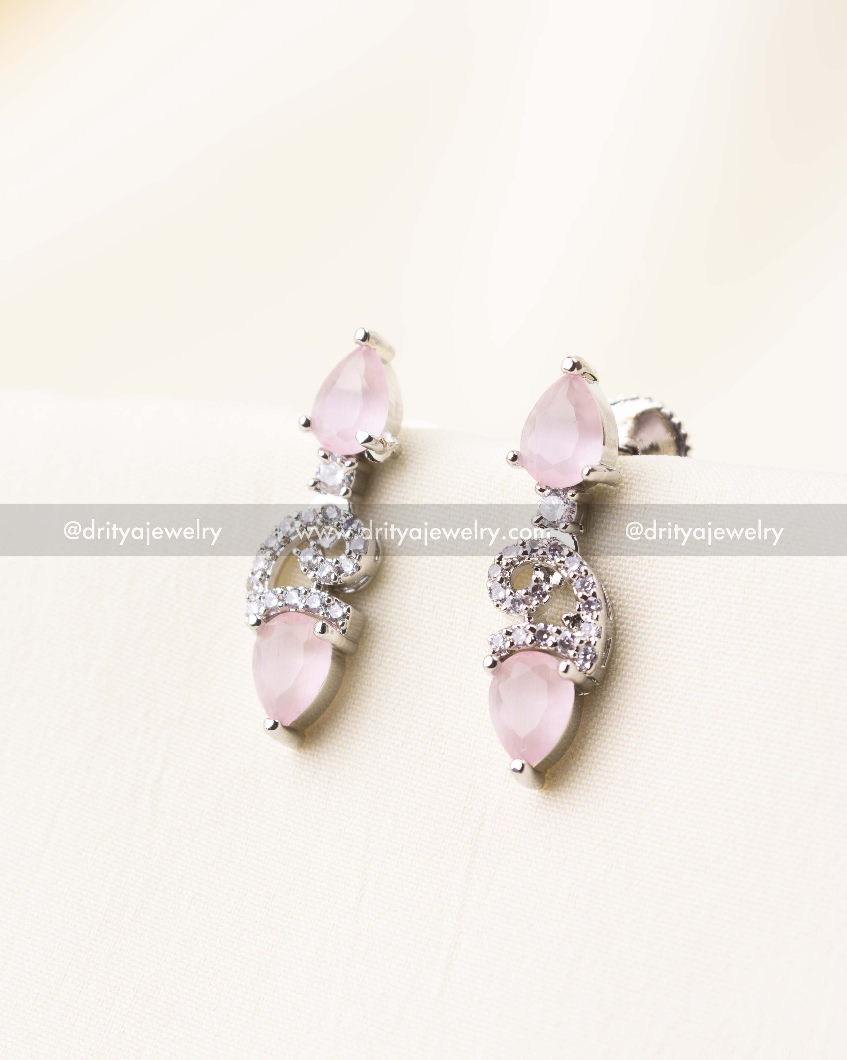 Elegant blush pink drop earrings with dual-tone stonework and silver CZ detailing.