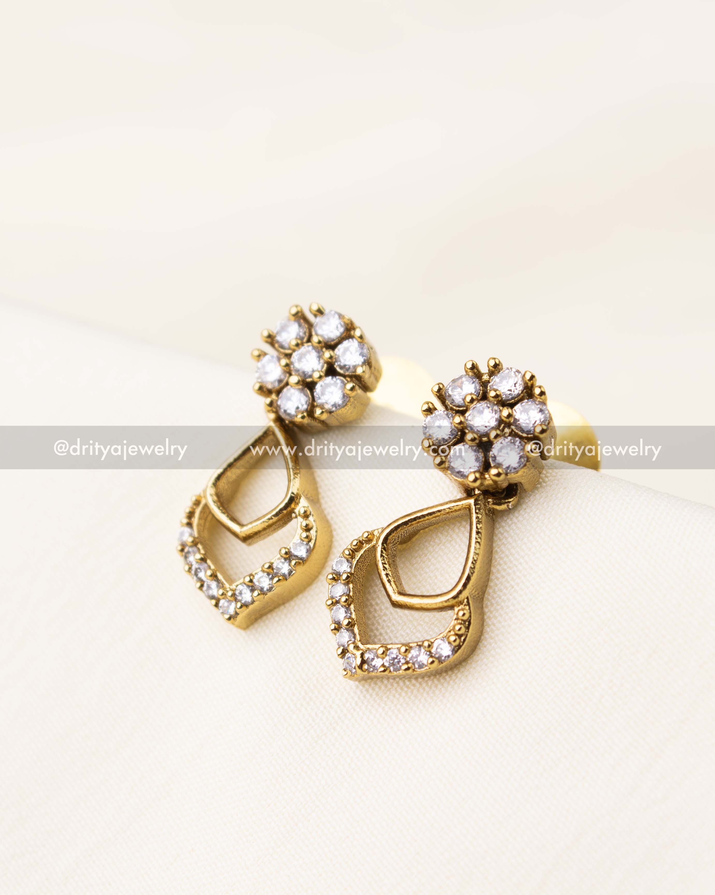 Earrings with round floral CZ tops and teardrop-shaped gold dangles