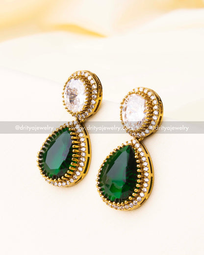 Close-up of drop earrings with green and white CZ stones in teardrop and oval shapes