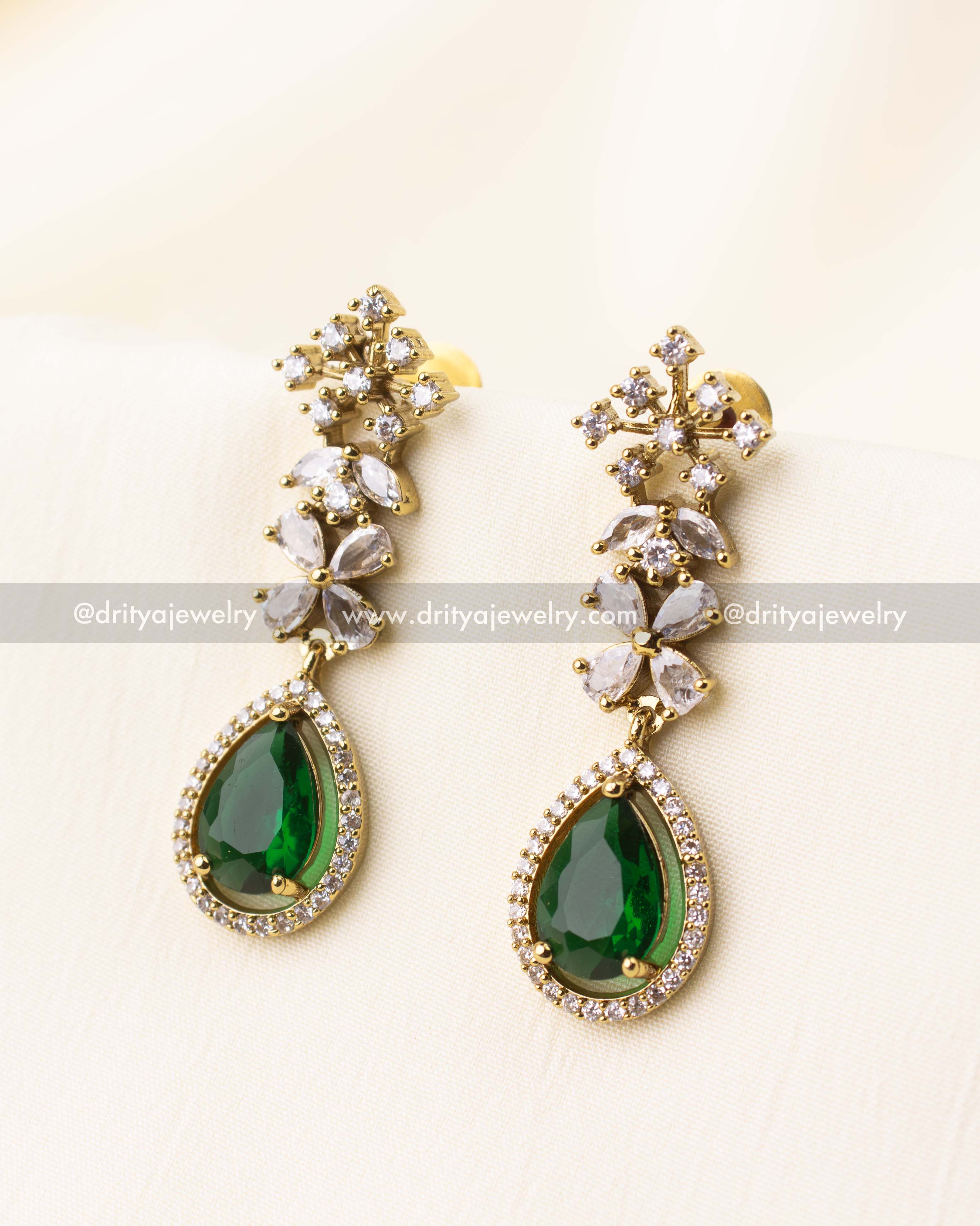 Matching long earrings with emerald green stones and CZ floral detailing